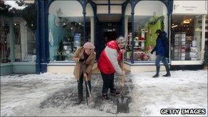 Shopkeepers clear snow from the street in Wells, Somerset (20 Dec 2010)