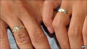 A couple holds hands showing their wedding rings during a wedding in Manila