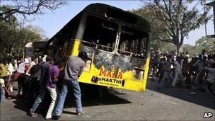 Indian students pull a burnt bus to block the road, during a protest demanding the creation of a separate Telangana state, in Hyderabad, 7 January 2011