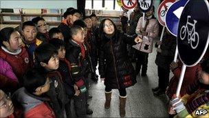 Chinese children holding traffic signs undergo a class on traffic security and manners, at a school in Dongyang in China's Zhejiang province, 20 January 2011