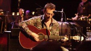 Jim Corr playing an acoustic guitar