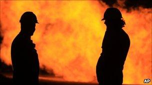 Oil workers next to a natural gas flame