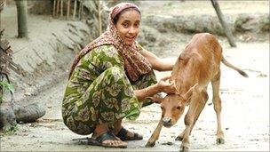 Woman in a village with a calf