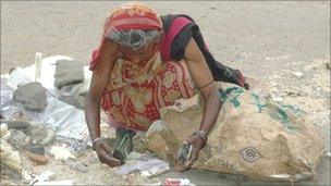 Woman looking through rubbish to see if anything can be salvaged - photo James Melik