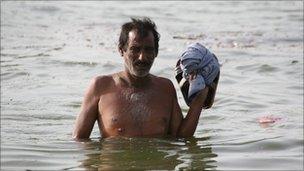 A man wades through floodwater in Sindh, Pakistan, in September 2010