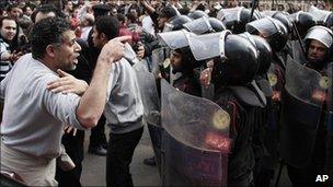 Demonstrator confronts riot police.