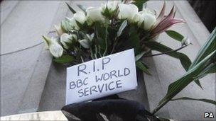 Protesters leave sign saying 'RIP World Service' outside BBC building