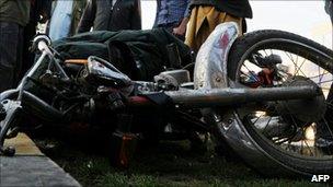 Onlookers surrounding the motor bike of a commuter who was killed