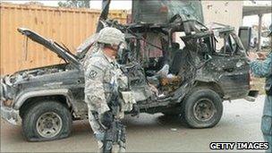 US troops and Afghan police inspect the wreckage of the deputy governor's car in Kandahar. Photo: 29 January 2011