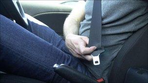 A man does up his seat belt