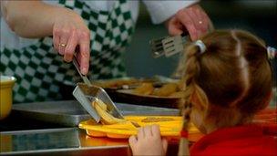 Pupil being served school meal