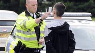 Police officer checking youth's pupil dilation