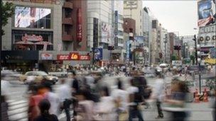 Pedestrians crossing busy street in Tokyo