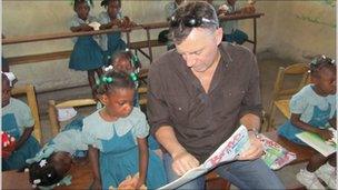 Duncan Bannatyne with children in Cite Soleil, Haiti