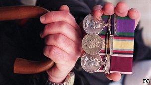 An armed forces veteran holds his medals