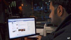 A man uses Facebook in a cafe