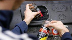 Man putting glasses into a recycling container