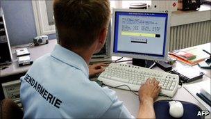 French policeman examining a computer hard drive - file pic