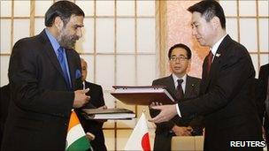 India's Trade Minister Anand Sharma and Japan's Foreign Minister Seiji Maehara exchange documents.