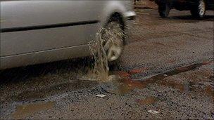 Car driving over potholes