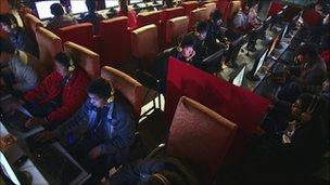 People use computers at an internet cafe in in central China's Anhui province