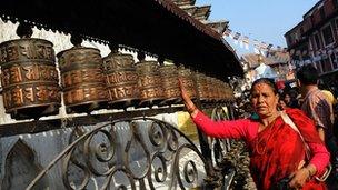 Woman spinning a prayer wheel