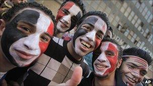 Young Egyptians wearing facepaint in the colors of the national flag arrive at Tahrir square to celebrate the fall of the regime of former President Hosni Mubarak one week ago, 18 February 2011