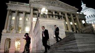 Congressmen walk down the steps of the House of Representatives as they work throughout the night on a spending bill.