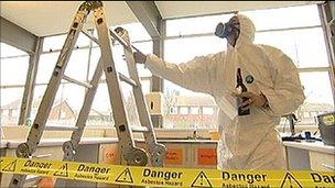 Workman removing asbestos from a school