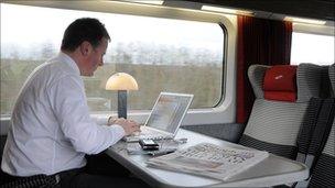 man working at computer on train