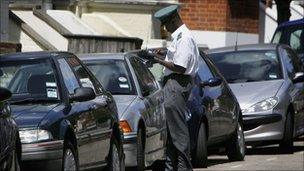 Parked cars and a traffic warden