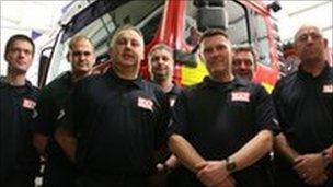 Some of the firefighters standing in front of a fire engine
