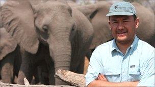 Jose Cortes standing in front on herd of elephant