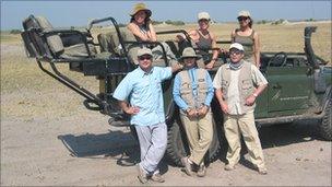 Group of people in front of a four-wheel drive vehicle