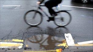 Cyclist avoids a pothole on Mansfield Road, Nottingham