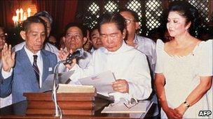 Ferdinand Marcos takes the oath of office on 24 February 1986 in Manila while his wife Imelda looks on