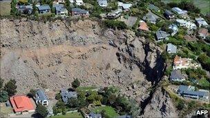 Homes stand on the edge of a landslide in the Christchurch suburb of Sumner on Thursday 24 February