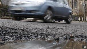 A car passes a pothole (Photo: Danny Lawson/PA Wire)