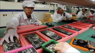 Staff members work on the production line at the Foxconn