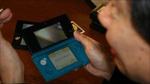 Shigeru Miyamoto holds up the Nintendo 3DS