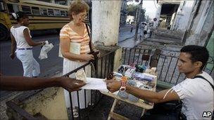 Eddy Cantallos attends to customers after receiving his new license to sell goods in front of a home in the El Cerro neighbourhood in Havana in January 2011