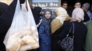 People queue to buy bread in the Fashloum district of Tripoli, 26 Feb