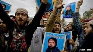 Supporters of various religious parties hold images of Malik Mumtaz Hussain Qadri and chant slogans in support of Qadri, the gunman detained for the killing of Punjab Governor Salman Taseer, outside Adiala Jail in Rawalpindi on 14 February 2011