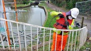 Chris Eade from Bristol removes paint from the Bath Top Lock footbridge on the Kennet and Avon Canal in Bath