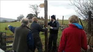 Workers installing a signpost on the Beacons Way