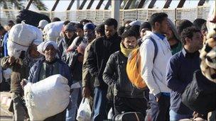 Egyptian evacuees from Libya queue at Djerba airport in Tunisia to board their flight back home