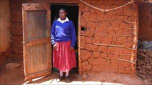 A schoolgirl in Tanzania standing outside a ghetto