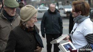 Volunteer Annette Fenner hands out books for World Book Night, in Balham, south London