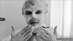 A woman applying face cream with her hands