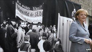 Angela Merkel in front of a picture showing the 1990 storming of the Stasi headquarters in Berlin, 2009